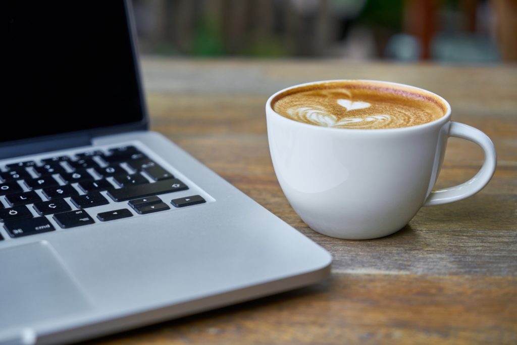 Foto von einer Tasse Kaffee und einem Notebook